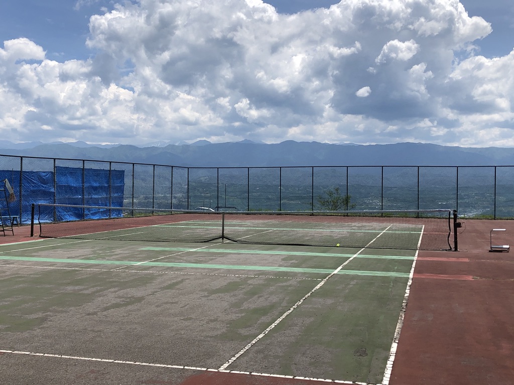 剝げたテニスコートと赤石山脈